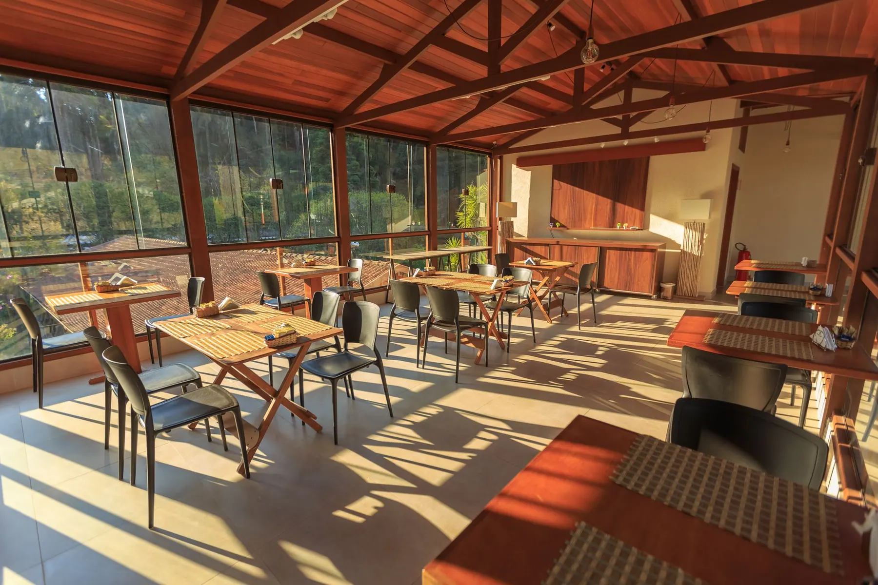 Heller Gastraum mit Fensterfront zur Terrasse