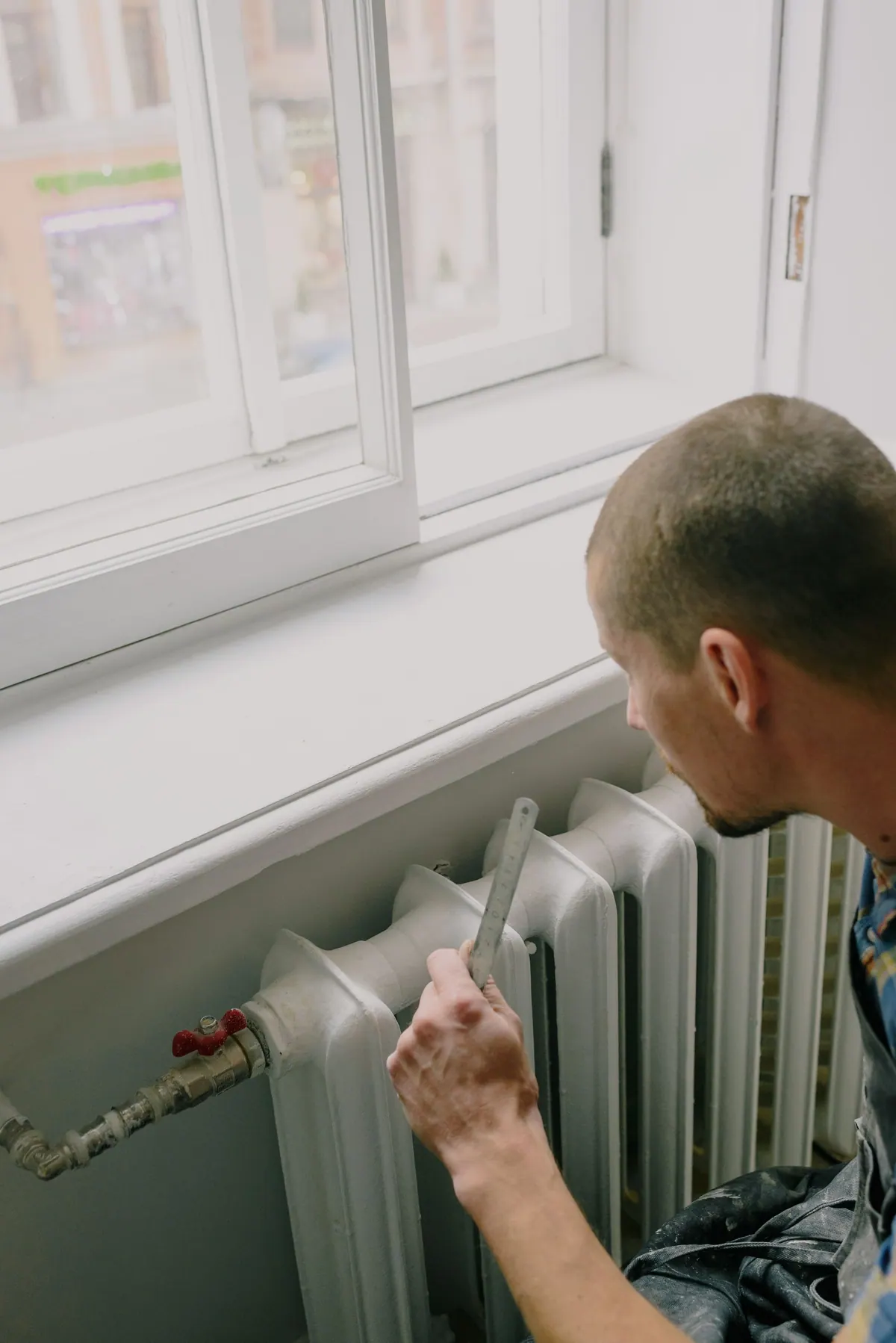 Heizkörper unter einem Fenster wird entlüftet